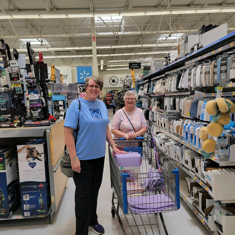 Elder Orphan Care board member and volunteer Ellen helps older friend Janice shop for bedsheets