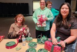 Some of many Elder Orphan Care volunteers who wrap gifts and make bows