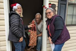 Elder Orphan Care Volunteers Sandy and Karen deliver a Christmas Totebag of Joy to an older friend